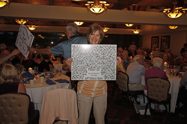 Marcia Baker-Hoogstra holding her raffle prize - a collage of our senior pictures
